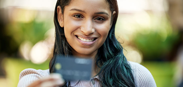 Woman smiling while holding a credit card