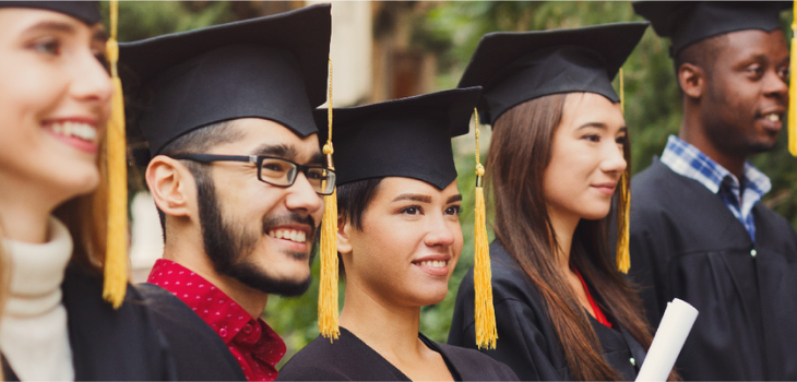 Smiling high school graduates receiving their diplomas.